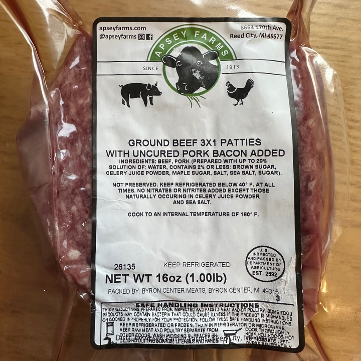 Packaged ground beef patties with a label on a wooden surface